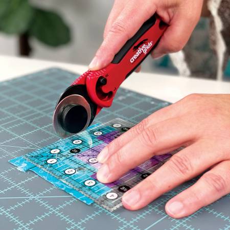 The Creative Grids® 45mm rotary cutter is designed with you in mind. The sleek red metal body adds weight to the cutter so less pressure is required when cutting fabric. The cushioned comfort grip is designed to fit your hand, reducing slips and muscle fatigue.