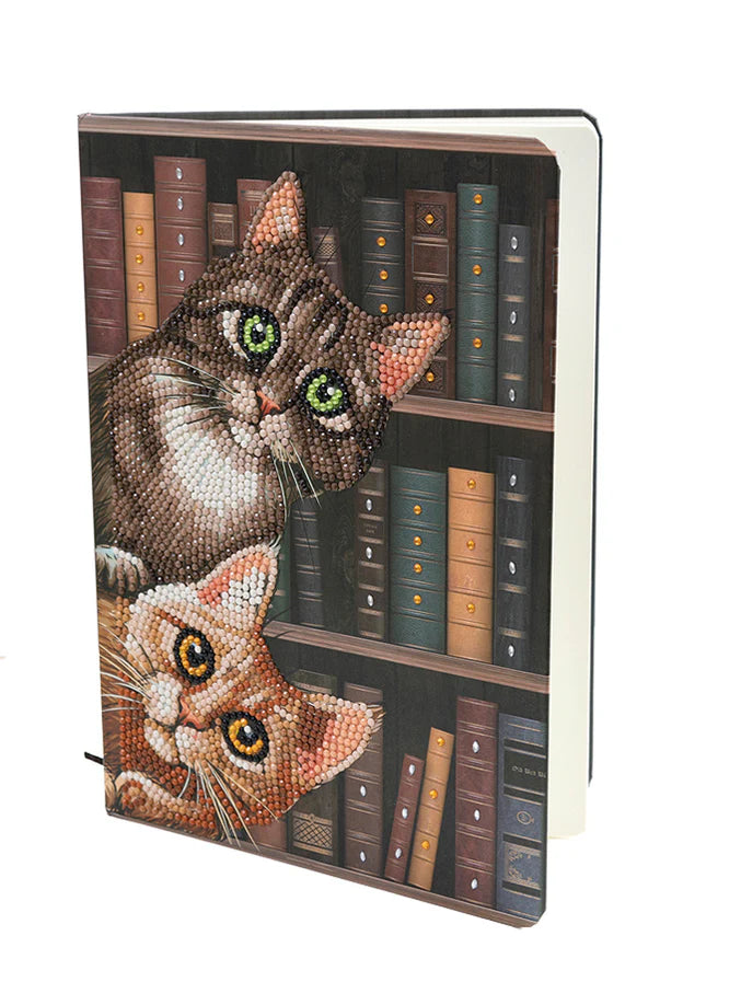 Cats in the Library Notebook Kit - Crystal Art-Get ready to literally make your thoughts dazzle! Create a sparkling stationary cover with the Crystal Art Notebook Kit that comes complete with all the tools and 50 lined pages to record your notes. Give it as a brilliant gift, take it to school, or use as a journal. Approximately 2 to 3 hours assembly time. Notebook size is 6.9" x 10". Suitable for ages 8+
