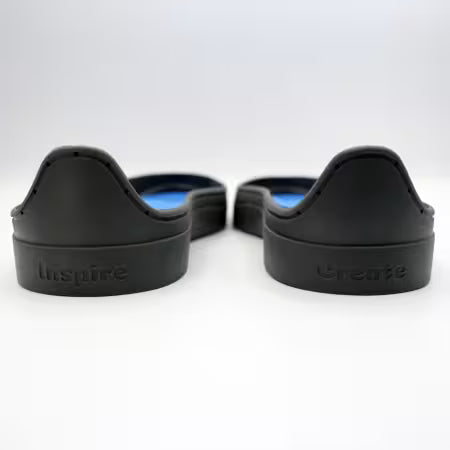 Patchwork Kicks back view of blue shoe inserts in dark gray rubber sneaker soles.
