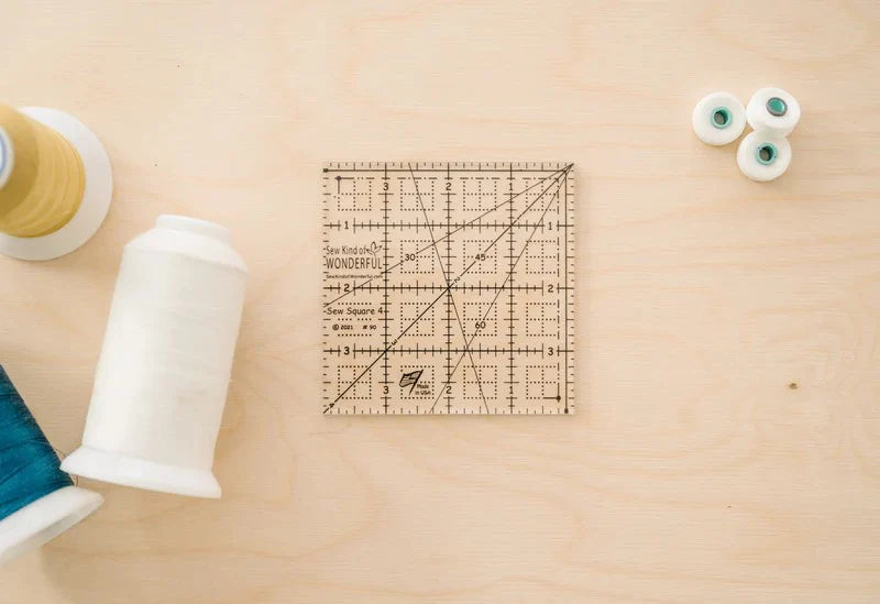 Sew Square 4™ - Sew Kind of Wonderful
Sew Square 4™ is a 4" x 4" clear acrylic ruler with easy to use black lines and marks.
Sew Square 4™ has unique marks for squaring up 4" x 4" units from multiple Sew Kind of Wonderful patterns.